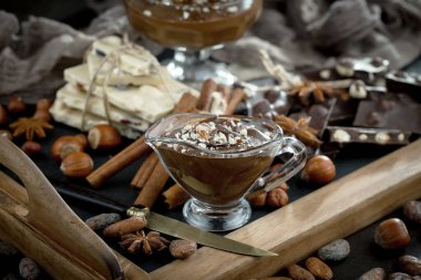 Eskimiş bir arka planda kakao çekirdeği ve fındıklı siyah çikolata..