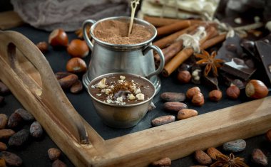 Eskimiş bir arka planda kakao çekirdeği ve fındıklı siyah çikolata..