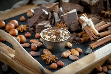 Eskimiş bir arka planda kakao çekirdeği ve fındıklı siyah çikolata..