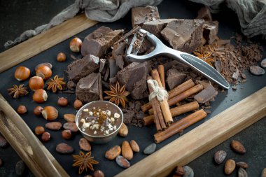 Eskimiş bir arka planda kakao çekirdeği ve fındıklı siyah çikolata..