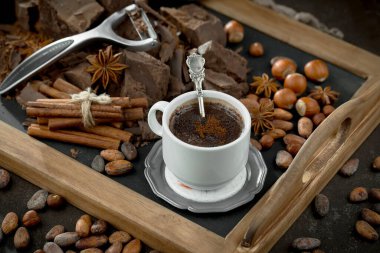 Eskimiş bir arka planda kakao çekirdeği ve fındıklı siyah çikolata..