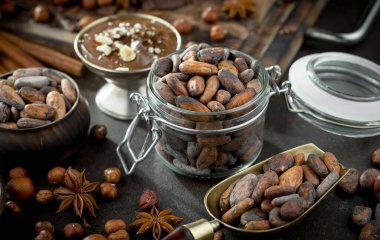 Eskimiş bir arka planda kakao çekirdeği ve fındıklı siyah çikolata..