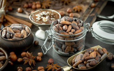 Eskimiş bir arka planda kakao çekirdeği ve fındıklı siyah çikolata..