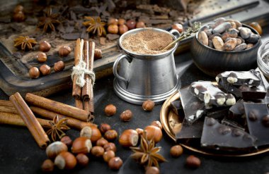 Eskimiş bir arka planda kakao çekirdeği ve fındıklı siyah çikolata..