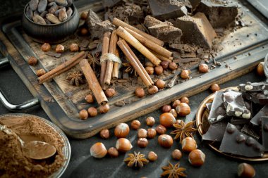 Eskimiş bir arka planda kakao çekirdeği ve fındıklı siyah çikolata..