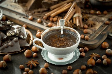 Eskimiş bir arka planda kakao çekirdeği ve fındıklı siyah çikolata..