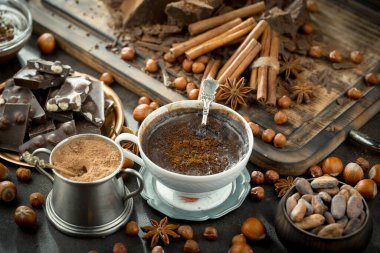 Eskimiş bir arka planda kakao çekirdeği ve fındıklı siyah çikolata..