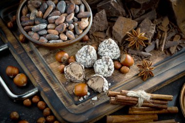 Kakao çekirdeğinin arka planında koyu çikolata ve mutfak malzemeleri.