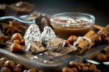 Kakao çekirdeğinin arka planında koyu çikolata ve mutfak malzemeleri.