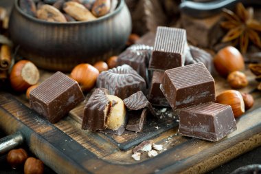 Kakao çekirdeğinin arka planında koyu çikolata ve mutfak malzemeleri.