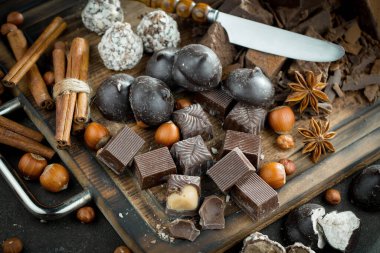 Kakao çekirdeğinin arka planında koyu çikolata ve mutfak malzemeleri.