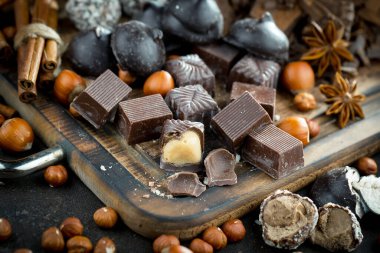 Kakao çekirdeğinin arka planında koyu çikolata ve mutfak malzemeleri.