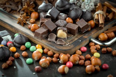 Kakao çekirdeğinin arka planında koyu çikolata ve mutfak malzemeleri.