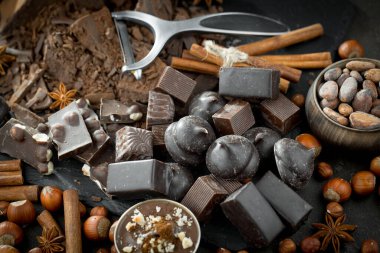 Kakao çekirdeğinin arka planında koyu çikolata ve mutfak malzemeleri.