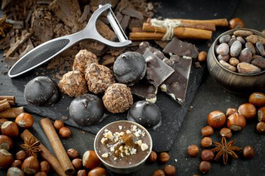 Kakao çekirdeğinin arka planında koyu çikolata ve mutfak malzemeleri.