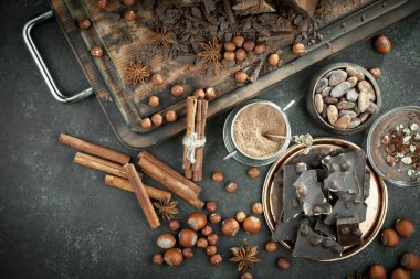Kakao çekirdeğinin arka planında koyu çikolata ve mutfak malzemeleri.