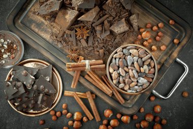 Kakao çekirdeğinin arka planında koyu çikolata ve mutfak malzemeleri.