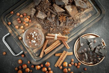 Kakao çekirdeğinin arka planında koyu çikolata ve mutfak malzemeleri.