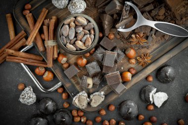 Kakao çekirdeğinin arka planında koyu çikolata ve mutfak malzemeleri.