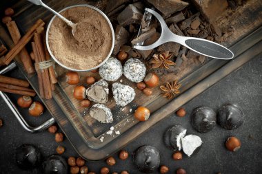 Kakao çekirdeğinin arka planında koyu çikolata ve mutfak malzemeleri.