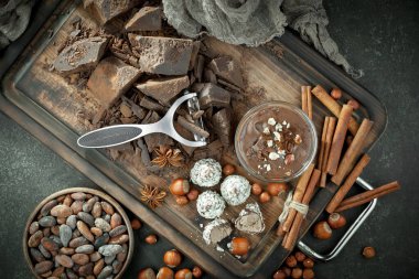 Kakao çekirdeğinin arka planında koyu çikolata ve mutfak malzemeleri.