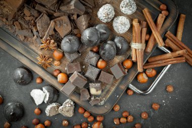 Kakao çekirdeğinin arka planında koyu çikolata ve mutfak malzemeleri.