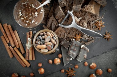 Kakao çekirdeğinin arka planında koyu çikolata ve mutfak malzemeleri.