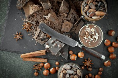 Kakao çekirdeğinin arka planında koyu çikolata ve mutfak malzemeleri.