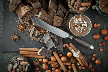 Kakao çekirdeğinin arka planında koyu çikolata ve mutfak malzemeleri.