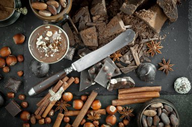 Kakao çekirdeğinin arka planında koyu çikolata ve mutfak malzemeleri.