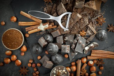 Kakao çekirdeğinin arka planında koyu çikolata ve mutfak malzemeleri.