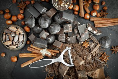 Kakao çekirdeğinin arka planında koyu çikolata ve mutfak malzemeleri.