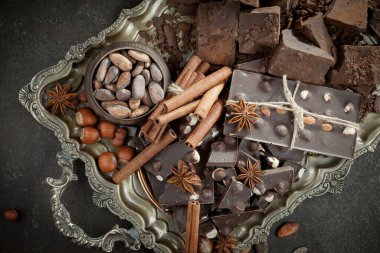 Kakao çekirdeğinin arka planında koyu çikolata ve mutfak malzemeleri.