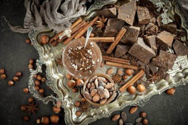 Kakao çekirdeğinin arka planında koyu çikolata ve mutfak malzemeleri.