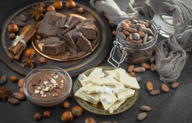 Kakao çekirdeğinin arka planında koyu çikolata ve mutfak malzemeleri.