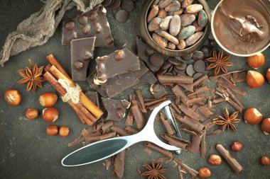 Kakao çekirdeğinin arka planında koyu çikolata ve mutfak malzemeleri.