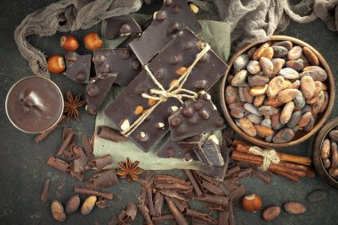 Kakao çekirdeğinin arka planında koyu çikolata ve mutfak malzemeleri.