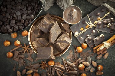 Kakao çekirdeğinin arka planında koyu çikolata ve mutfak malzemeleri.