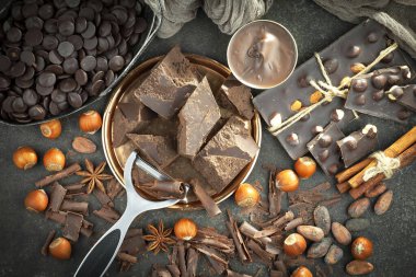 Kakao çekirdeğinin arka planında koyu çikolata ve mutfak malzemeleri.