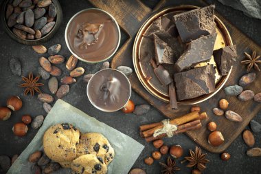 Kakao çekirdeğinin arka planında koyu çikolata ve mutfak malzemeleri.