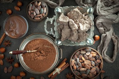 Kakao çekirdeğinin arka planında koyu çikolata ve mutfak malzemeleri.