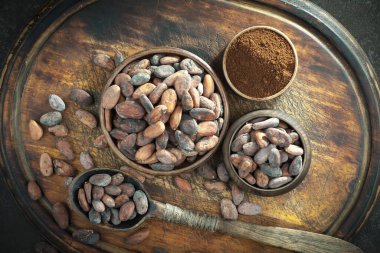 Kakao çekirdeğinin arka planında koyu çikolata ve mutfak malzemeleri.