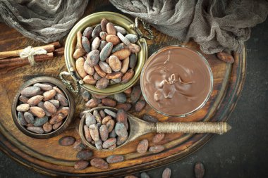 Kakao çekirdeğinin arka planında koyu çikolata ve mutfak malzemeleri.