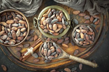 Kakao çekirdeğinin arka planında koyu çikolata ve mutfak malzemeleri.