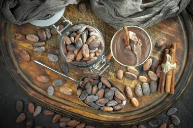 Kakao çekirdeğinin arka planında koyu çikolata ve mutfak malzemeleri.