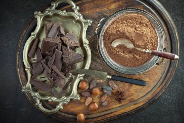 Kakao çekirdeğinin arka planında koyu çikolata ve mutfak malzemeleri.