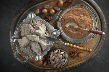Kakao çekirdeğinin arka planında koyu çikolata ve mutfak malzemeleri.