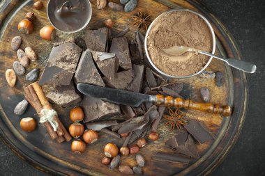 Kakao çekirdeğinin arka planında koyu çikolata ve mutfak malzemeleri.