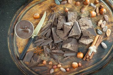 Kakao çekirdeğinin arka planında koyu çikolata ve mutfak malzemeleri.