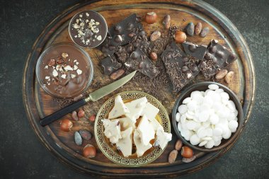 Kakao çekirdeğinin arka planında koyu çikolata ve mutfak malzemeleri.